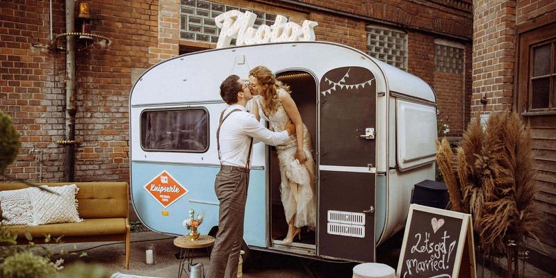 Küssendes Brautpaar vor dem Vintage Fotobox Camper "das Knipserle" für Ihre Hochzeit oder Feier in Stuttgart und Umgebung
