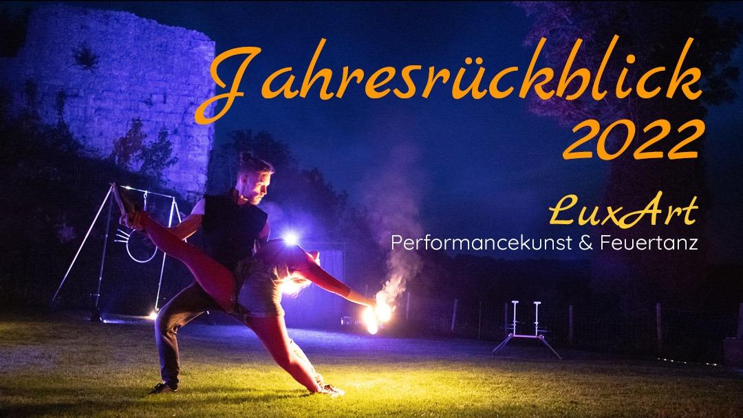 Titelbild zum Jahresrückblick 2022: Artisten zeigen eine Spagat Paar Tanz Figur bei einer Feuershow vor der Kulisse der Maisenburg.