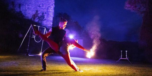 R Inszenierung Feuershow und Feuertanz Artisten Ehepaar aus Stuttgart zeigt Spagat Tanzfigur LuxArt Performancekunst